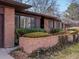 Close-up of the brick exterior of a home with well-maintained landscaping at 2433 S Oneida St, Denver, CO 80224