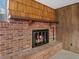 A cozy brick fireplace with a wooden mantel and wood accents at 2433 S Oneida St, Denver, CO 80224
