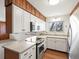 Kitchen with updated stainless steel appliances, white cabinets, and butcher block countertops at 2433 S Oneida St, Denver, CO 80224