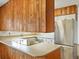Kitchen island with a stainless steel refrigerator and overhead wood storage at 2433 S Oneida St, Denver, CO 80224