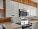 Kitchen with updated stainless steel microwave and a cooktop island with bright countertops at 2433 S Oneida St, Denver, CO 80224