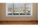 Bright living room featuring beautiful hardwood floors, large window, and neutral wall color at 2433 S Oneida St, Denver, CO 80224