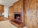 Close-up of wood-burning fireplace with decorative tiling and wood-paneled wall at 2433 S Oneida St, Denver, CO 80224