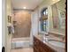 Elegant bathroom featuring a granite countertop vanity, soaking tub with tiled surround, and ample natural light at 445 Madison N St, Denver, CO 80206