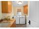 Well-lit laundry room with granite countertops, ample cabinet space and modern washer and dryer at 445 Madison N St, Denver, CO 80206