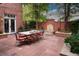Private outdoor patio featuring a fountain, seating, mature landscaping, and a brick surround at 445 Madison N St, Denver, CO 80206