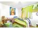 A bedroom with a quirky religious print, desk, and bright green decorations is ready for a new look at 6933 W 52Nd Pl, Arvada, CO 80002