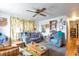 Bright living room featuring a ceiling fan, patterned curtains, and wood floors at 6933 W 52Nd Pl, Arvada, CO 80002