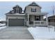 Two-story house with gray siding, a large garage, and a covered porch at 16592 E 109Th Ave, Commerce City, CO 80022