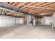 Unfinished basement with exposed wooden beams, utilities, and concrete floors at 15122 Uinta St, Thornton, CO 80602