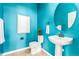 Stylish powder room boasts bright blue walls, pedestal sink, and updated fixtures at 15122 Uinta St, Thornton, CO 80602