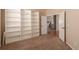 Bedroom with shelving unit, carpet flooring, and open doorway to hallway and stairs at 15122 Uinta St, Thornton, CO 80602