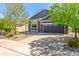 Lovely gray home with stone accents, a two-car garage, a well-maintained driveway and landscaped front yard at 15122 Uinta St, Thornton, CO 80602