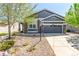 Charming exterior view of gray home with a two car garage, stone accents, and well-manicured landscaping at 15122 Uinta St, Thornton, CO 80602