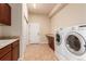 Spacious laundry room with wash basin, machines, built-in cabinets, and tile floors at 15122 Uinta St, Thornton, CO 80602