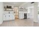Stylish bar area featuring white cabinets, floating shelves, a beverage fridge, and modern finishes at 6991 S Lee Way, Littleton, CO 80127