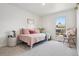 Bright bedroom featuring a stylish daybed with plush pillows and a view of the neighborhood at 6991 S Lee Way, Littleton, CO 80127
