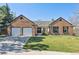 Charming brick home with a well-manicured lawn, two-car garage, and inviting entryway at 6991 S Lee Way, Littleton, CO 80127