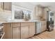 A sunlit kitchen offers stainless appliances, wood cabinets, and quartz countertops at 6991 S Lee Way, Littleton, CO 80127