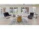 Bright living area with a zebra-print rug, accent furniture, and large windows providing ample natural light at 6991 S Lee Way, Littleton, CO 80127