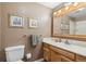 Bathroom featuring a wooden vanity, medicine cabinet and tiled shower in neutral tones at 10596 Ura Ln, Northglenn, CO 80234