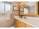 Bathroom vanity with light wood cabinets and a large framed mirror at 10596 Ura Ln, Northglenn, CO 80234