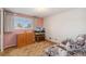 Cozy bedroom with a plush couch, wood dresser and a window providing natural light at 10596 Ura Ln, Northglenn, CO 80234