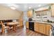 Functional kitchen with wood cabinets, black appliances and eat in table at 10596 Ura Ln, Northglenn, CO 80234