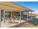 A covered patio is shown with a table, chairs, and view of the backyard at 10596 Ura Ln, Northglenn, CO 80234