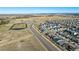 Expansive aerial view of a residential area featuring houses, schools, and roads nestled in a vast landscape at 55 S Edge Cliff St, Castle Rock, CO 80104