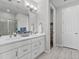 Well-lit bathroom featuring double sinks, a glass-enclosed shower, light gray paint, and modern fixtures at 55 S Edge Cliff St, Castle Rock, CO 80104
