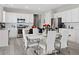 Modern kitchen with stainless steel appliances, white cabinetry, a tile backsplash, and a marble-topped table at 55 S Edge Cliff St, Castle Rock, CO 80104