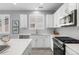 Bright kitchen features white cabinetry, stainless steel appliances, and quartz countertops at 55 S Edge Cliff St, Castle Rock, CO 80104