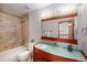 Bathroom showcasing tub with tiled shower, glass sink bowl vanity, and large mirror at 8753 W Cornell Ave # 12-1, Denver, CO 80227