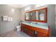 Bathroom features a double sink vanity with cherry cabinets, large mirror, and modern light fixtures at 8753 W Cornell Ave # 12-1, Denver, CO 80227