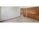 A neutral carpeted bedroom featuring a closet and view of another room at 8753 W Cornell Ave # 12-1, Denver, CO 80227