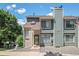 A townhouse with brick and green facade featuring a chimney and nearby trees at 8753 W Cornell Ave # 12-1, Denver, CO 80227