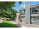 A townhouse with neutral tones featuring a chimney and manicured yard at 8753 W Cornell Ave # 12-1, Denver, CO 80227