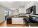 Updated kitchen features counter seating, granite countertops, and modern appliances at 8753 W Cornell Ave # 12-1, Denver, CO 80227