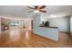 Open living space with hardwood floors flowing to kitchen and a brick fireplace at 8753 W Cornell Ave # 12-1, Denver, CO 80227