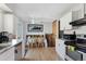 Bright dining area features modern appliances, white cabinets, and hardwood floors at 1655 S Quintero Way, Aurora, CO 80017