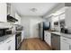 A modern kitchen with stainless steel appliances, granite countertops, and white cabinets at 1655 S Quintero Way, Aurora, CO 80017