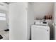 Bright laundry room with a modern washer and ample storage space and a partial view of the bathroom at 1655 S Quintero Way, Aurora, CO 80017