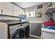 Laundry room with washer, dryer, and storage shelves at 6721 Birch St, Commerce City, CO 80022