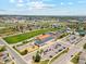 An aerial shot showcases a well maintained school with playground, parking, and vast greenery in a picturesque neighborhood at 3595 W 67Th S Ave, Denver, CO 80221
