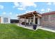 Back patio with string lights, outdoor furniture and grill, overlooking a grassy backyard and shed at 3595 W 67Th S Ave, Denver, CO 80221