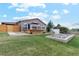 Large grassy backyard featuring a deck, rock garden, and white gazebo-style structure at 3595 W 67Th S Ave, Denver, CO 80221