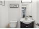 Cozy half bathroom with a dark vanity, modern sink, and convenient toilet location at 3595 W 67Th S Ave, Denver, CO 80221