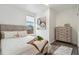 Bright bedroom featuring a comfortable bed, a dresser, and a window for natural light at 3595 W 67Th S Ave, Denver, CO 80221
