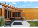 Outdoor pergola featuring seating and decorative woven black panels with a wooden privacy fence and rock landscaping at 3595 W 67Th S Ave, Denver, CO 80221